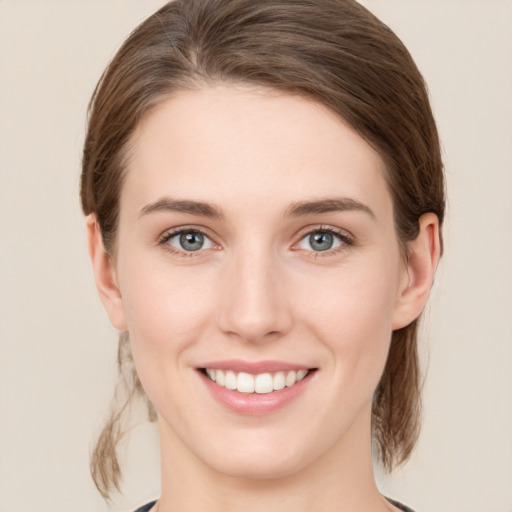 Joyful white young-adult female with medium  brown hair and green eyes