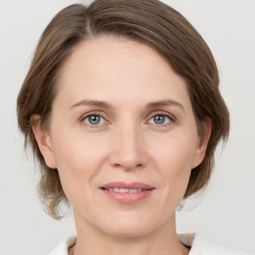 Joyful white adult female with medium  brown hair and grey eyes