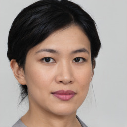 Joyful asian young-adult female with medium  black hair and brown eyes