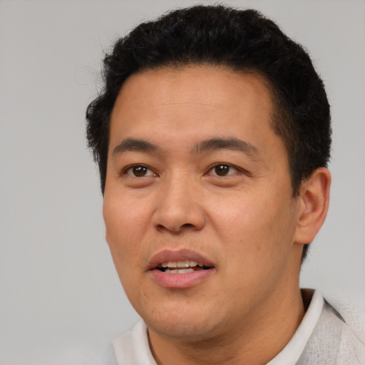 Joyful latino adult male with short  brown hair and brown eyes