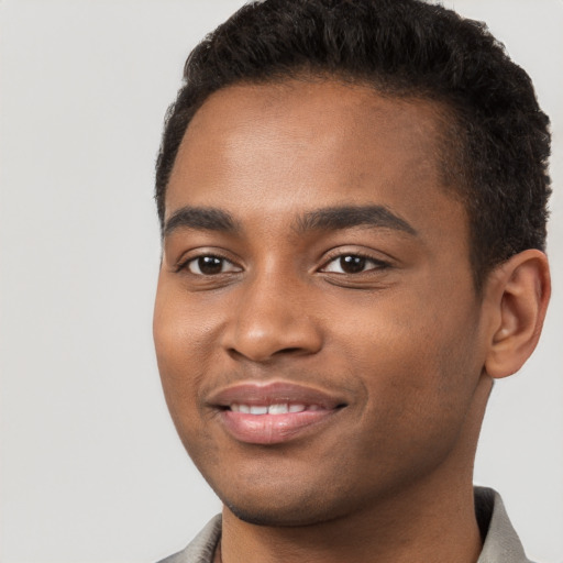 Joyful black young-adult male with short  brown hair and brown eyes