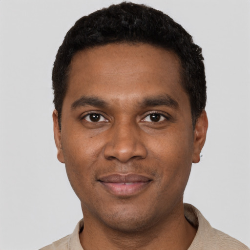 Joyful black young-adult male with short  black hair and brown eyes
