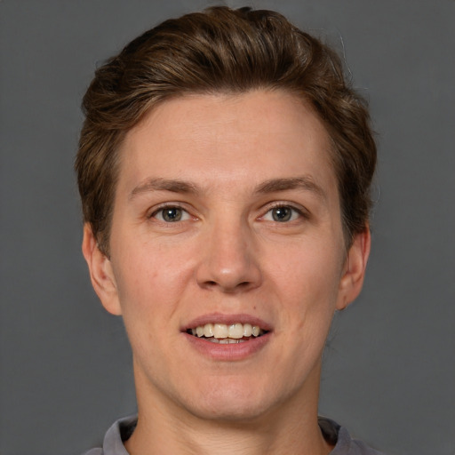 Joyful white adult male with short  brown hair and grey eyes