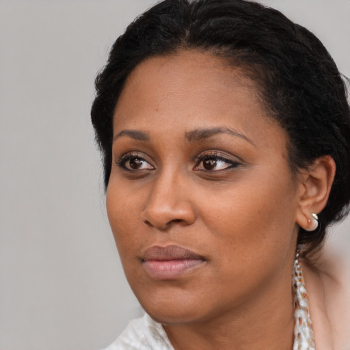 Joyful black young-adult female with medium  black hair and brown eyes