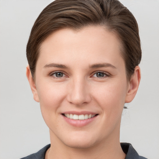 Joyful white young-adult female with short  brown hair and grey eyes