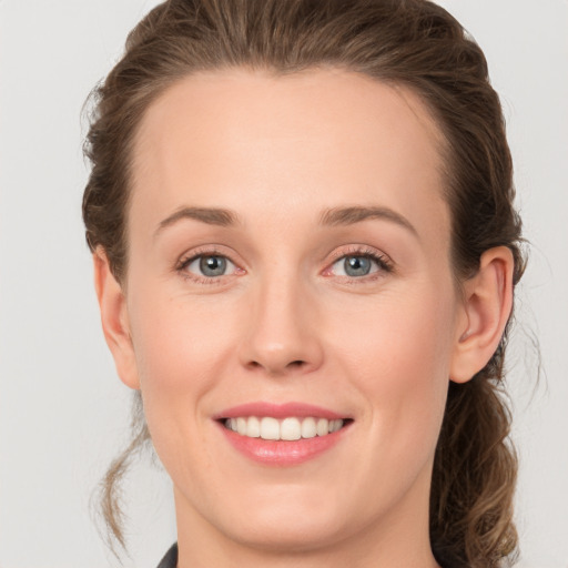 Joyful white young-adult female with medium  brown hair and grey eyes