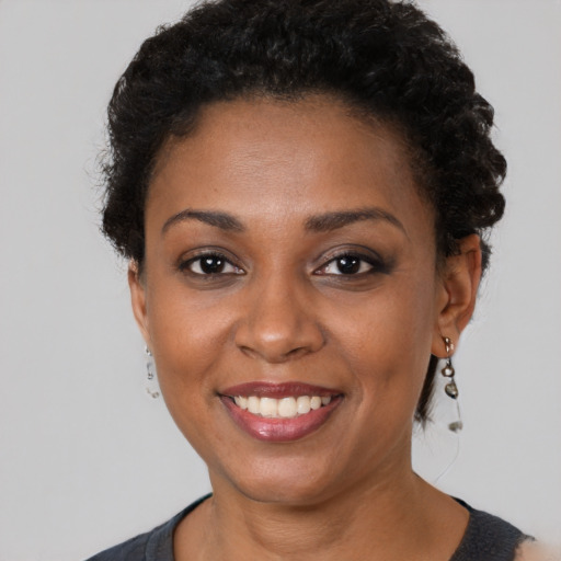 Joyful black young-adult female with short  brown hair and brown eyes