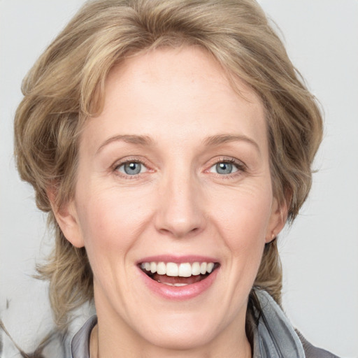 Joyful white adult female with medium  brown hair and blue eyes