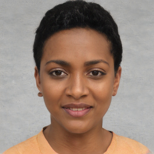 Joyful black young-adult female with short  black hair and brown eyes