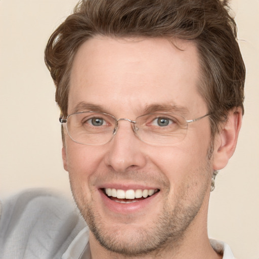 Joyful white adult male with short  brown hair and grey eyes