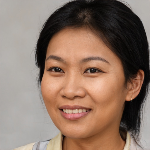 Joyful asian adult female with medium  brown hair and brown eyes