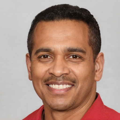 Joyful latino adult male with short  black hair and brown eyes