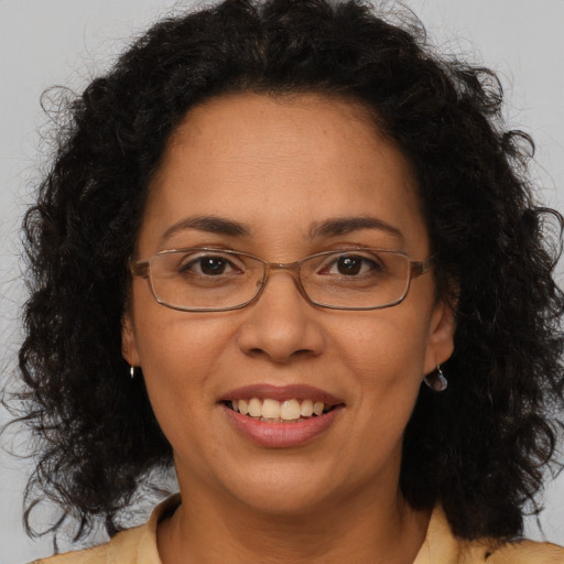 Joyful latino adult female with medium  brown hair and brown eyes