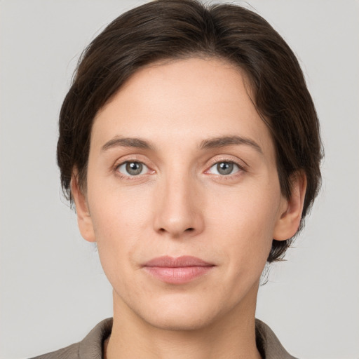 Joyful white young-adult female with short  brown hair and grey eyes