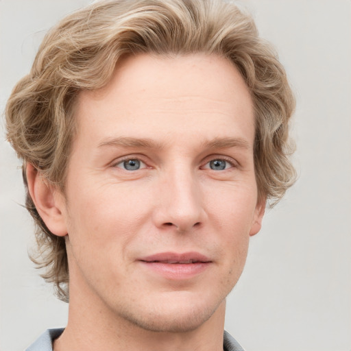 Joyful white young-adult male with short  brown hair and blue eyes