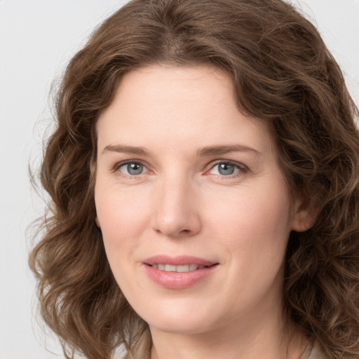 Joyful white young-adult female with long  brown hair and green eyes