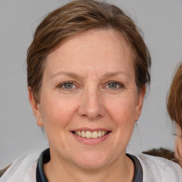 Joyful white adult female with medium  brown hair and blue eyes