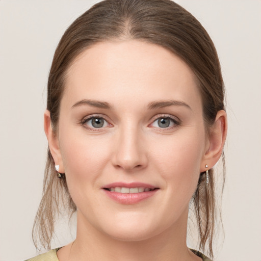 Joyful white young-adult female with medium  brown hair and grey eyes