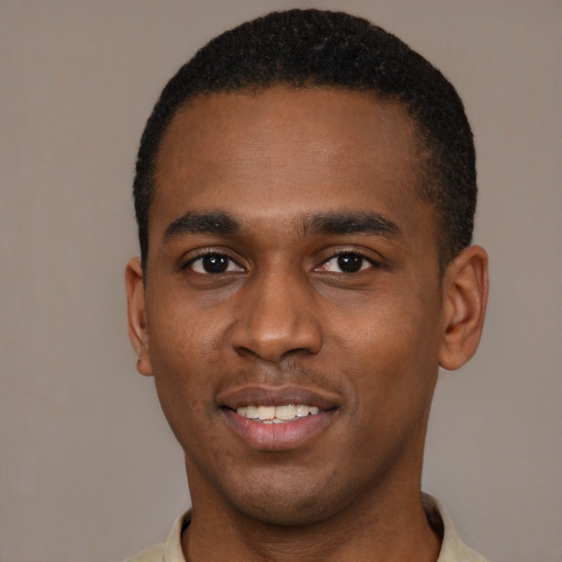 Joyful black young-adult male with short  black hair and brown eyes