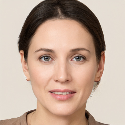 Joyful white young-adult female with medium  brown hair and grey eyes