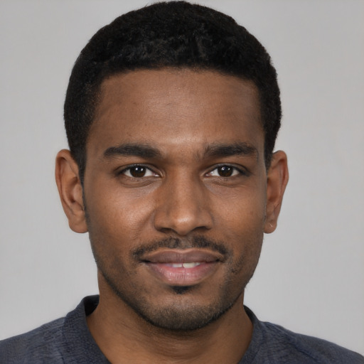 Joyful black young-adult male with short  black hair and brown eyes