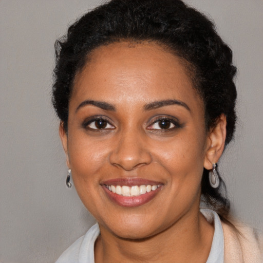 Joyful black young-adult female with short  black hair and brown eyes