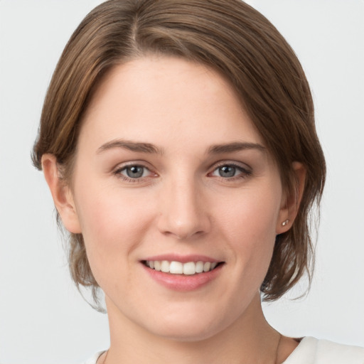 Joyful white young-adult female with medium  brown hair and grey eyes