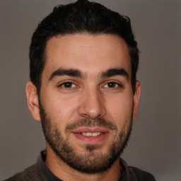Joyful white young-adult male with short  black hair and brown eyes