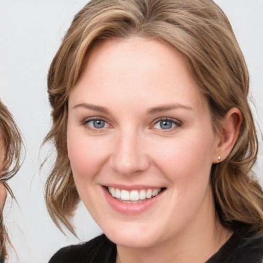 Joyful white young-adult female with medium  brown hair and blue eyes