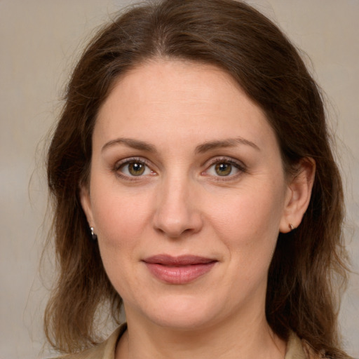 Joyful white young-adult female with medium  brown hair and green eyes