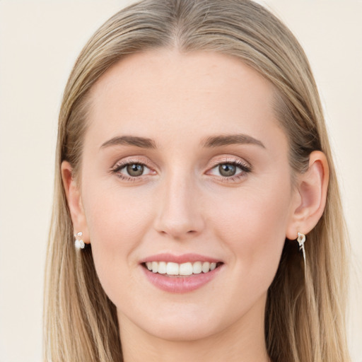 Joyful white young-adult female with long  brown hair and blue eyes