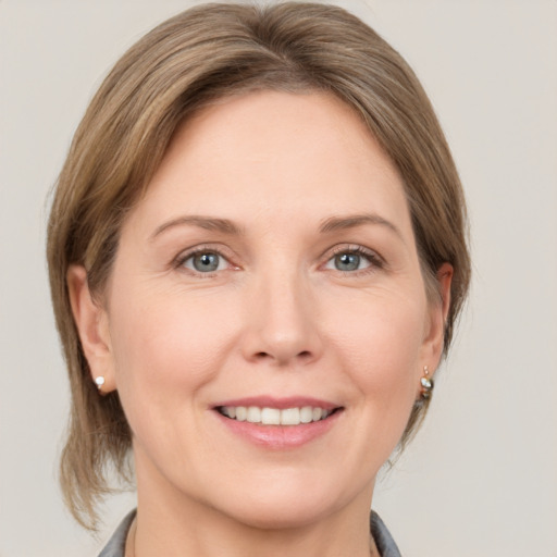 Joyful white adult female with medium  brown hair and grey eyes