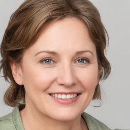 Joyful white adult female with medium  brown hair and blue eyes