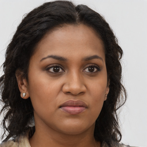 Joyful black young-adult female with long  brown hair and brown eyes