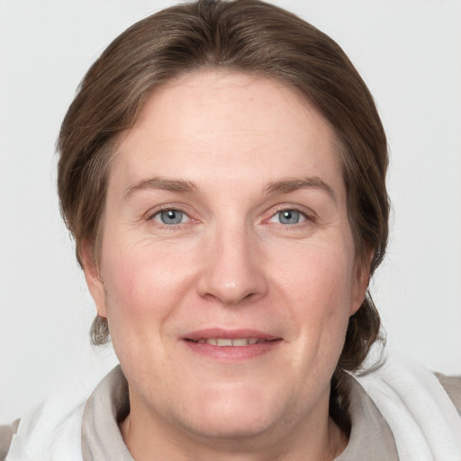 Joyful white adult female with medium  brown hair and grey eyes