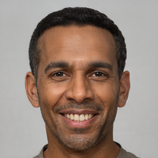 Joyful latino adult male with short  black hair and brown eyes