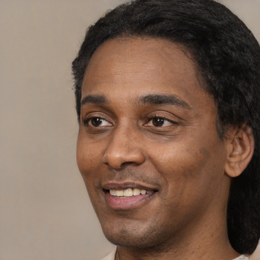 Joyful black adult male with short  black hair and brown eyes