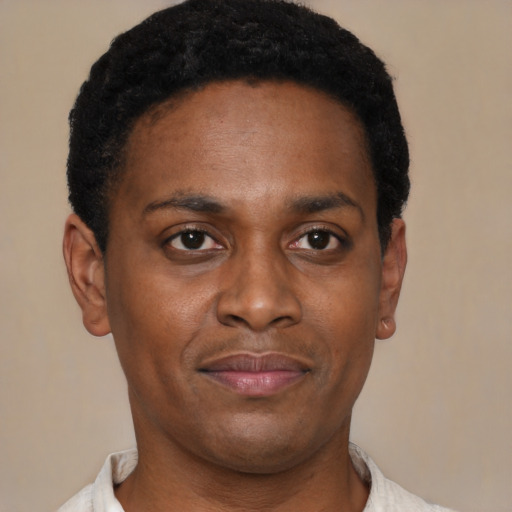 Joyful black young-adult male with short  black hair and brown eyes