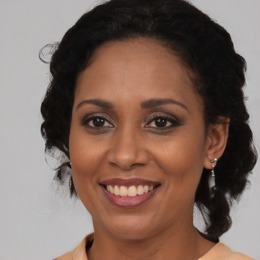 Joyful latino adult female with medium  brown hair and brown eyes