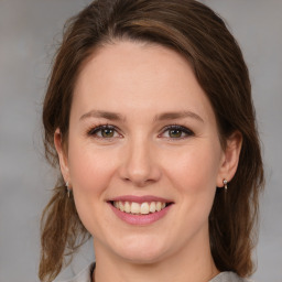 Joyful white young-adult female with medium  brown hair and grey eyes