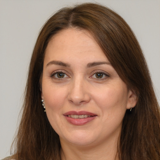 Joyful white adult female with long  brown hair and brown eyes