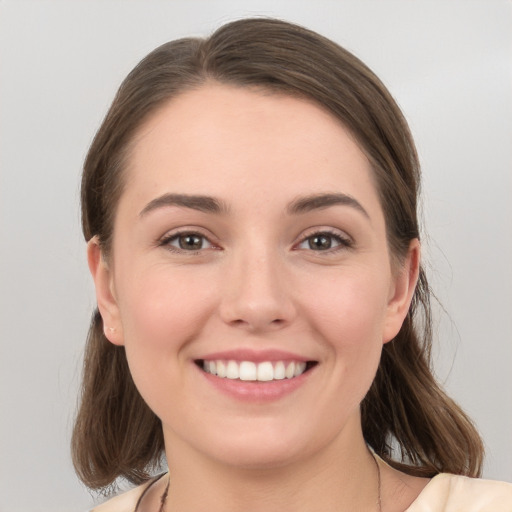 Joyful white young-adult female with medium  brown hair and grey eyes