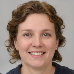 Joyful white adult female with medium  brown hair and blue eyes