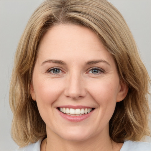 Joyful white young-adult female with medium  brown hair and green eyes