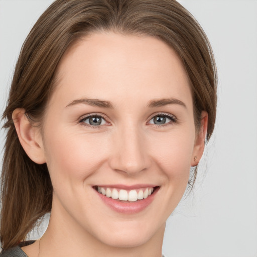 Joyful white young-adult female with medium  brown hair and grey eyes