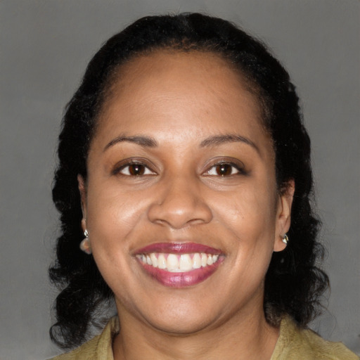 Joyful black adult female with medium  brown hair and brown eyes