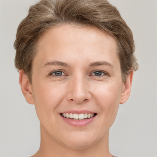 Joyful white young-adult female with short  brown hair and grey eyes