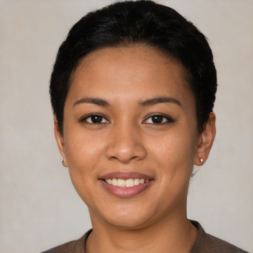 Joyful latino young-adult female with short  black hair and brown eyes