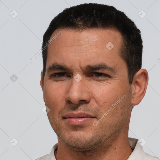 Joyful white adult male with short  black hair and brown eyes