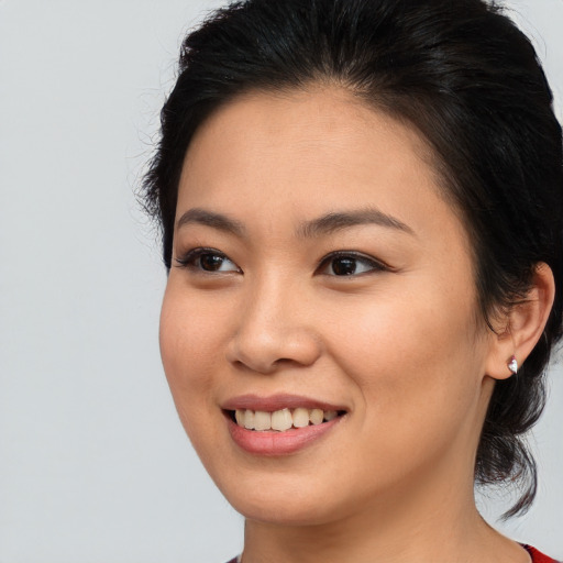 Joyful asian young-adult female with medium  brown hair and brown eyes